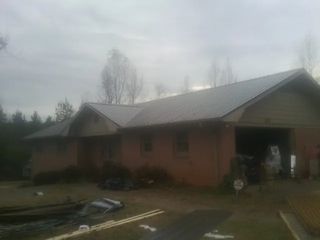 Gray metal roof on a stucco house with an attached garage in San Ysidro